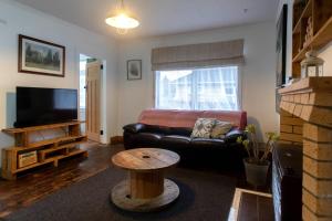 - un salon avec un canapé en cuir noir et une table dans l'établissement Devon Eleven, à Rotorua