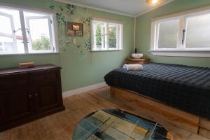 a bedroom with a bed and two windows at Devon Eleven in Rotorua