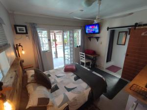 a living room with a couch and a tv at Paradise in the City Cottage Two in Port Elizabeth