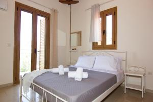 a bedroom with a bed with two towels on it at Emilia's Guest House Upper Floor in Stoupa