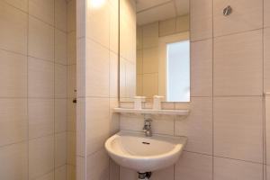 een badkamer met een wastafel en een spiegel bij Hôtel Montfort in Lourdes