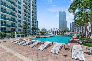 une piscine avec des chaises longues et un bâtiment dans l'établissement Brickell 2 Story Luxury Getaway With Pool, à Miami