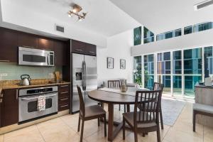 une cuisine avec une table et des chaises ainsi qu'une cuisine avec une cuisinière dans l'établissement Brickell 2 Story Luxury Getaway With Pool, à Miami