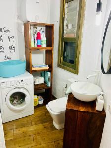 uma casa de banho com uma máquina de lavar roupa e um lavatório em Garancor em Valleseco