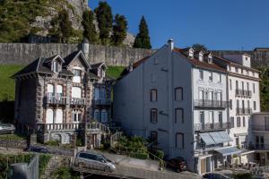 um grupo de edifícios ao lado de uma parede em Hôtel Montfort em Lourdes