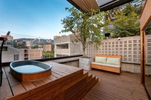 a hot tub sitting on a wooden deck with a couch at Celestino Boutique Hotel in Medellín