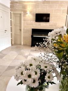 un vaso di fiori su un tavolo con un pianoforte di La Vetrana Rooms ad Avetrana