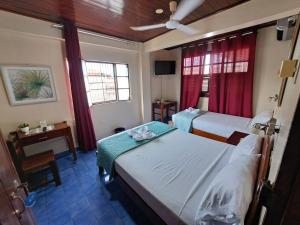 Habitación de hotel con 2 camas y mesa en Hotel Virrey Pucallpa EIRL en Pucallpa