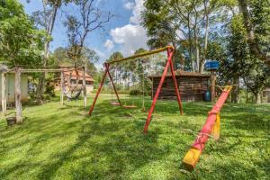un parc avec une balançoire vide installée dans l'herbe dans l'établissement Sitio CANTOS DA FLORESTA, à Mairinque