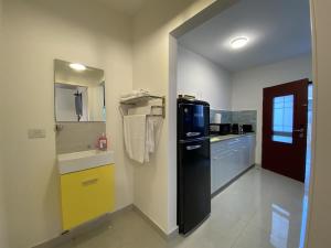 a kitchen with a black refrigerator and a sink at סויטות הר וים in Neve Zohar