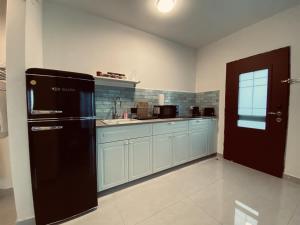 a kitchen with a black refrigerator and a sink at סויטות הר וים in Neve Zohar
