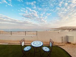 two tables and chairs on a balcony with a view of the ocean at סויטות הר וים in Neve Zohar