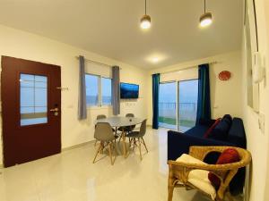 a living room with a table and a blue couch at סויטות הר וים in Neve Zohar