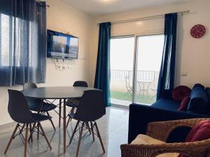 a living room with a table and chairs and a couch at סויטות הר וים in Neve Zohar +4 photos