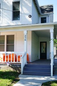 a front porch of a house with an orange chair at Beautiful Home Central Columbus in Columbus