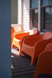 a row of orange benches sitting on a porch at Beautiful Home Central Columbus in Columbus