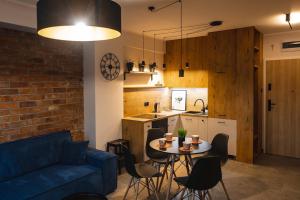 a living room with a blue couch and a table with chairs at Apartament Loft Mazury in Węgorzewo