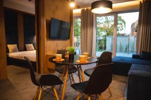 une chambre d'hôtel avec une table, des chaises et un lit dans l'établissement Apartament Loft Mazury, à Węgorzewo