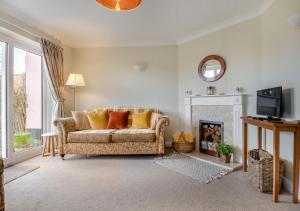 a living room with a couch and a fireplace at Honeysuckle in Halesworth