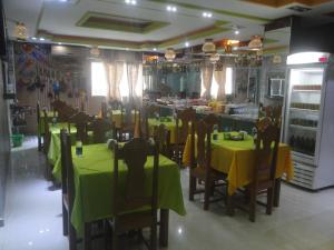 a restaurant with tables and chairs with green table cloth at Hotel Farol da Barra in Manaus