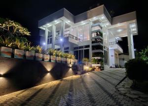 Un grand bâtiment blanc avec des lumières la nuit dans l'établissement Villa Water View, à Bandaragama