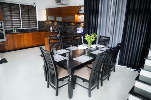 Bandaragama的住宿－Villa Water View，一间用餐室,配有黑色的桌子和椅子