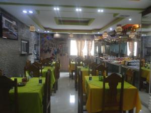 a restaurant with tables and chairs with yellow table cloth at Hotel Farol da Barra in Manaus