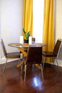 a dining room table and chairs with a yellow curtain at Cute Charming Vintage Townhome in German Village in Columbus