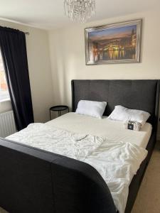 a bedroom with a large bed with a black headboard at The American style house in Kent