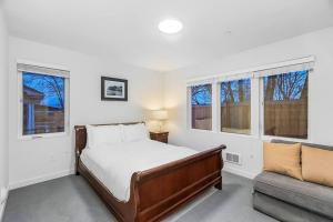 a bedroom with a bed and a couch and windows at The Sweetest Hideaway - 81 Walkscore! in Seattle