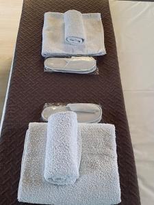 three towels on a table in a bathroom at Keskos Luxury Apartment in Athens