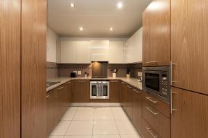 a large kitchen with wooden cabinets and appliances at Cape Royale Luxury Apartments by Stay In Luxury in Cape Town