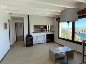 uma sala de estar com uma grande janela e um fogão em Apto. Ses Ancolles Vistas Mar em Cala Morell