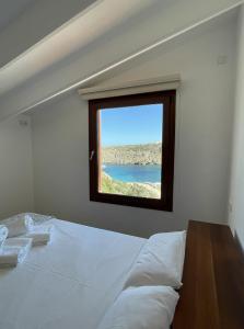 um quarto com uma cama grande e uma janela em Apto. Ses Ancolles Vistas Mar em Cala Morell