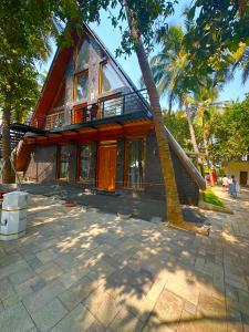 una casa con una palmera delante de ella en Moon Light Resorts, en Ammāpettai
