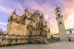 an old church with a clock tower and stairs at M&M Empedrada Apartamentos Jerez in Jerez de la Frontera