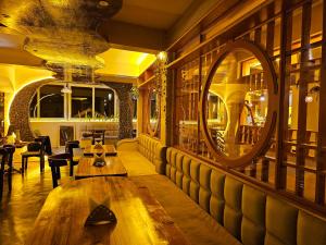 um restaurante com uma mesa de madeira e um espelho em Hotel Golden Orchid em Darjeeling