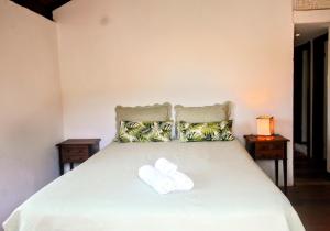 a bedroom with a bed with two towels on it at Casa da Vila in Tiradentes