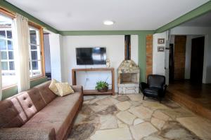 ein Wohnzimmer mit einem Sofa und einem Kamin in der Unterkunft Casa da Vila in Tiradentes