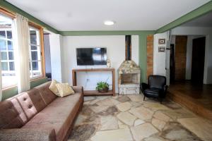 a living room with a couch and a fireplace at Casa da Vila in Tiradentes