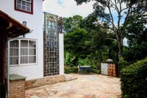 eine Terrasse außerhalb eines Hauses mit einem Tisch in der Unterkunft Casa da Vila in Tiradentes
