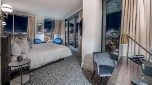 ケベック・シティーにあるLe Capitole Hotelのベッド付きのホテルルームで、市街の景色を望めます。