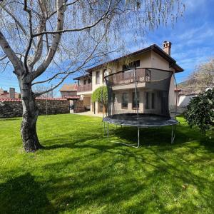 ein Haus mit einem Baum und einer Schaukel im Hof in der Unterkunft Villa Green Magic in Schipka