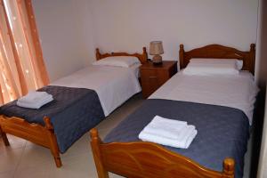 2 łóżka w sypialni z ręcznikami w obiekcie Villa Mira w mieście Ballaban
