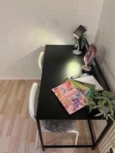 Apartment in Billund في بيلوند: طاولة سوداء عليها نبات ومصباح