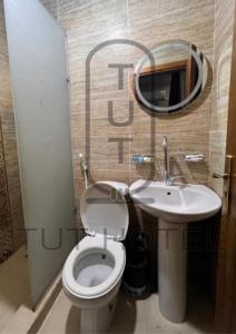 een badkamer met een toilet, een wastafel en een spiegel bij TUT Hotel Downtown in Caïro