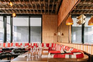 a restaurant with a long table and red chairs at Sonder at Britain Quay in Dublin
