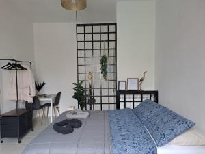 een slaapkamer met een bed met een blauw dekbed en een bureau bij A due passi da Milano - Rho Fiera - Malpensa - Como in Saronno