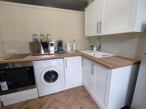 a kitchen with a washing machine and a sink at Le Naturel Clim, wifi, centre in Châteauroux +2 photos
