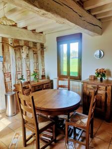 - une salle à manger avec une table et des chaises en bois dans l'établissement Gîtes les Deux Vallées, 